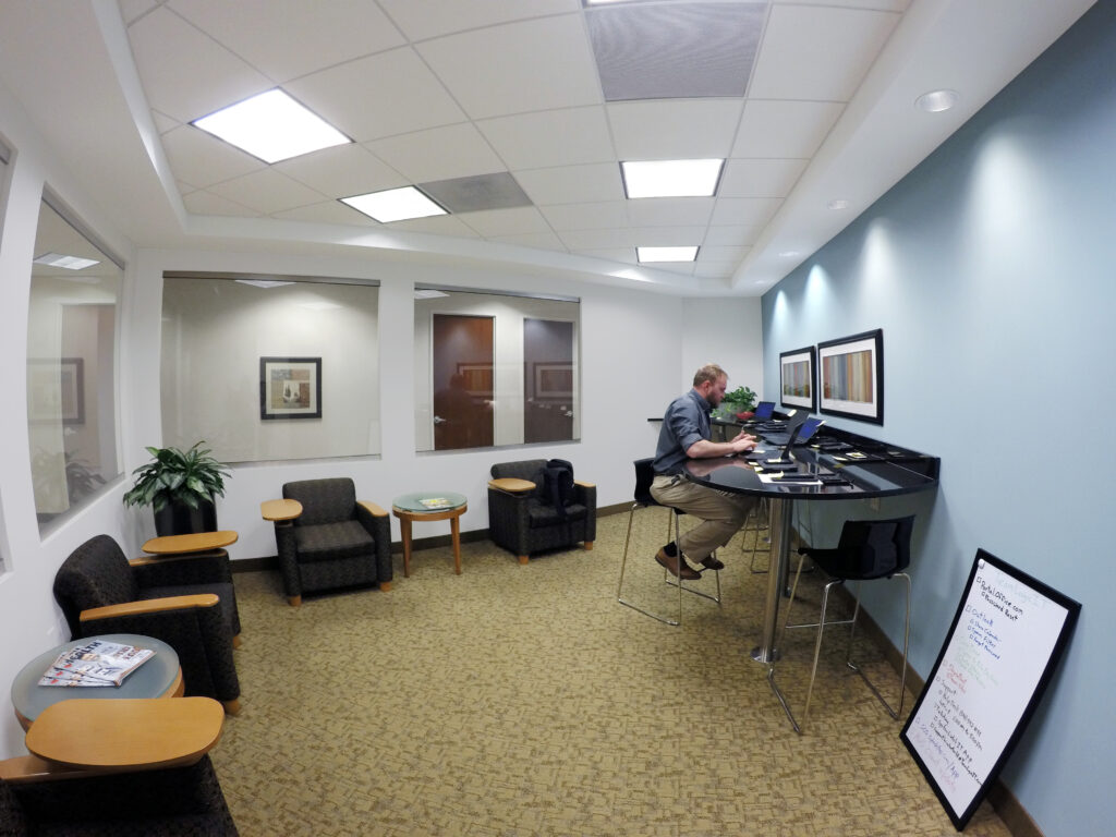 A man working at a shared workspace in an office.