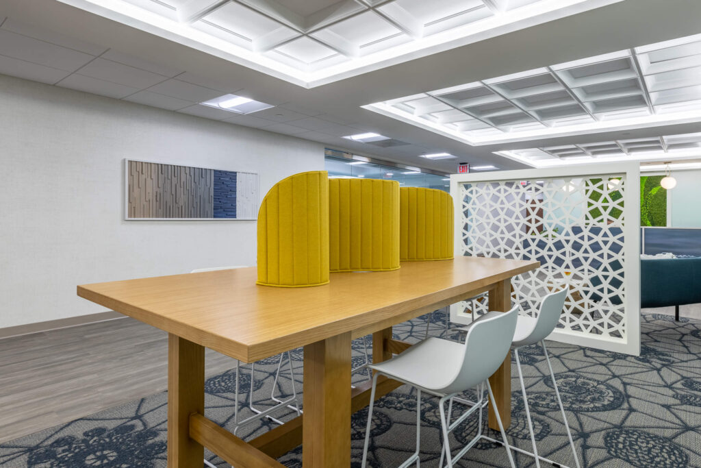 A coworking space furnished with a yellow table and chairs.