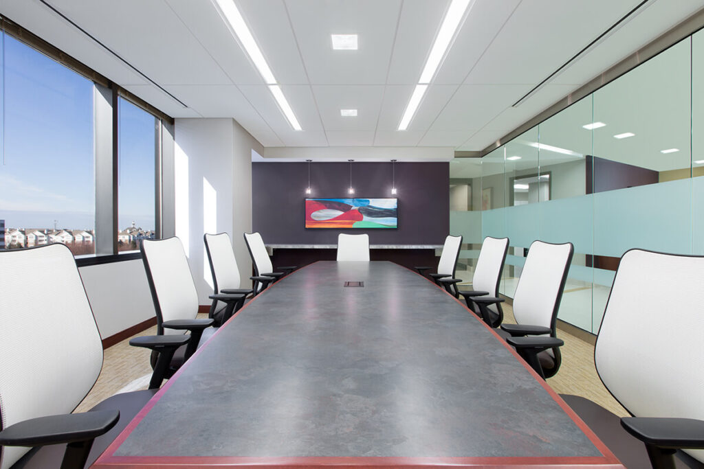 A conference room with meeting rooms equipped with a large table and chairs.