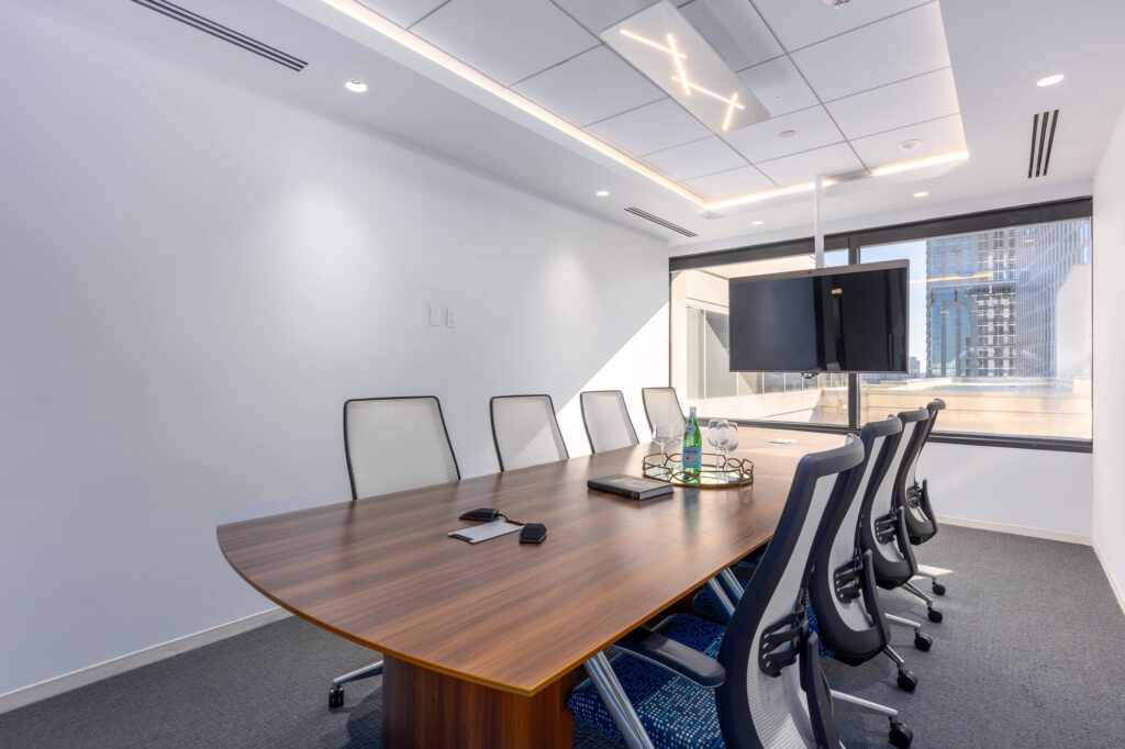 A meeting room with a large table and chairs.