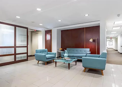 The lobby of an office building with blue furniture.