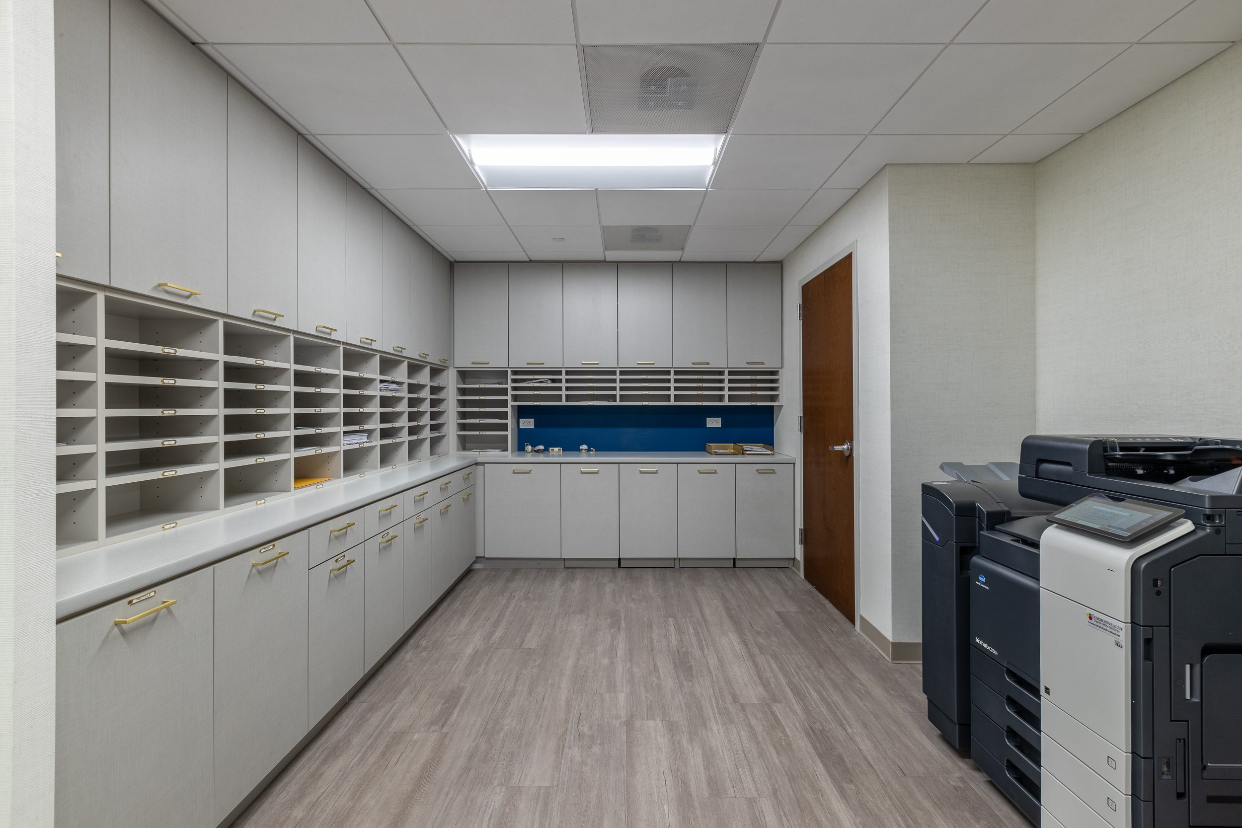 A home office with a printer and cabinets.