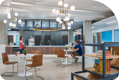 A group of people are sitting at a table in an office space.