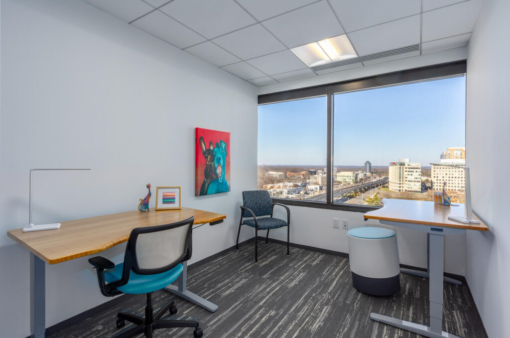 Office space for rent with a large city-view window.