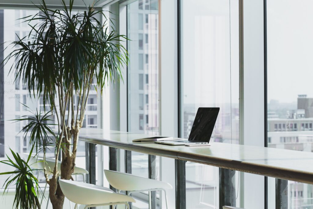 A coworking space with a white desk and a laptop on it.