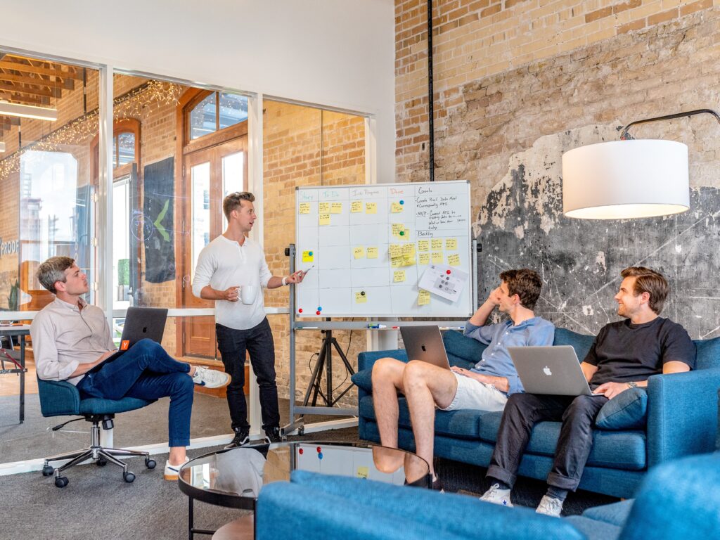 In a coworking space, a group of people sits around a table in an office.