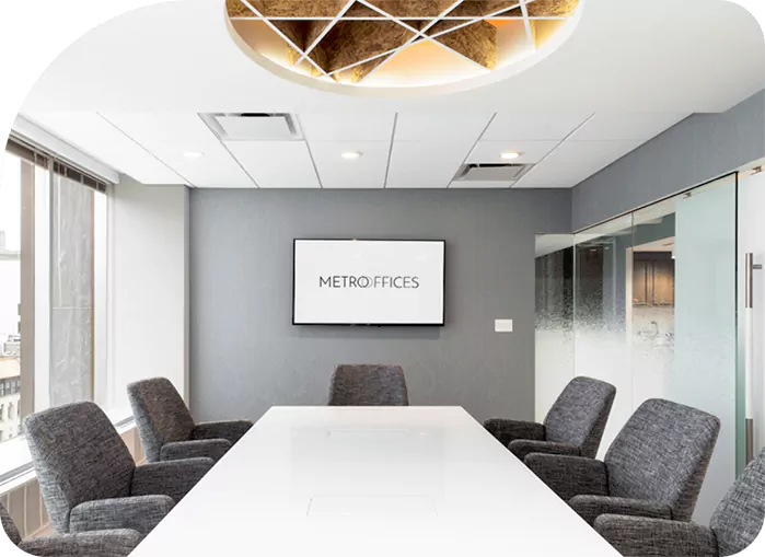 A meeting room with a white table and chairs.